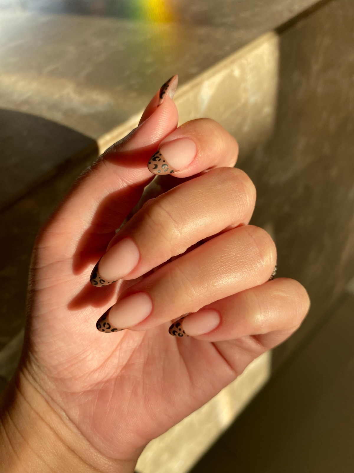 Mãos com nail art delicada em tons rosé e lavanda
